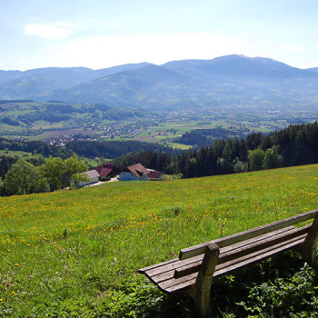 En benk på en ås med utsikt over Wolfsberg, Kärnten, Østerrike.